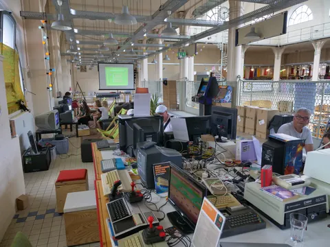 Halle voller Retro-Computer, Monitore und Besucher bei einer Vintage-IT-Ausstellung.