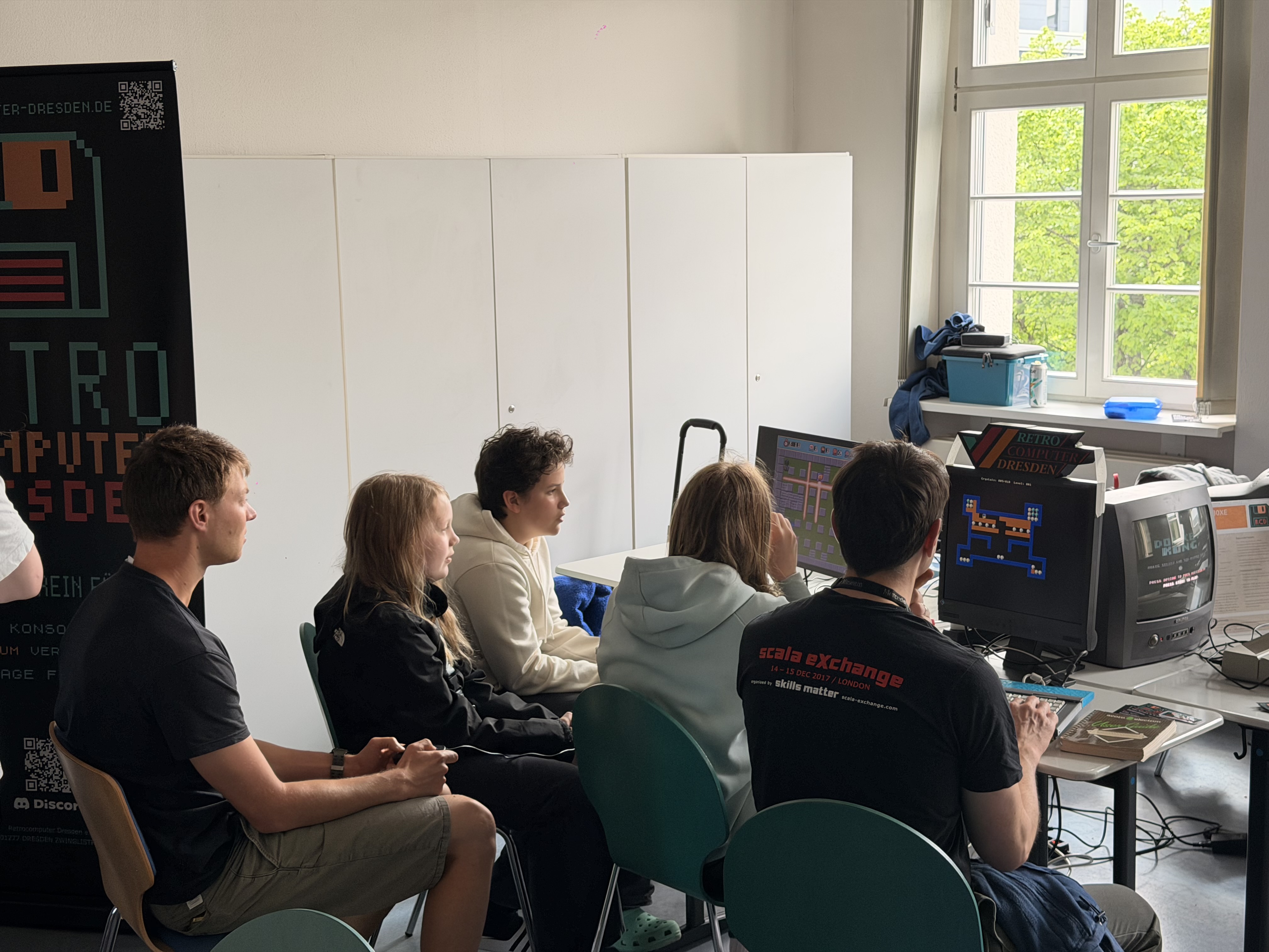 Menschen sitzen vor einem Bildschirm mit Bomberman